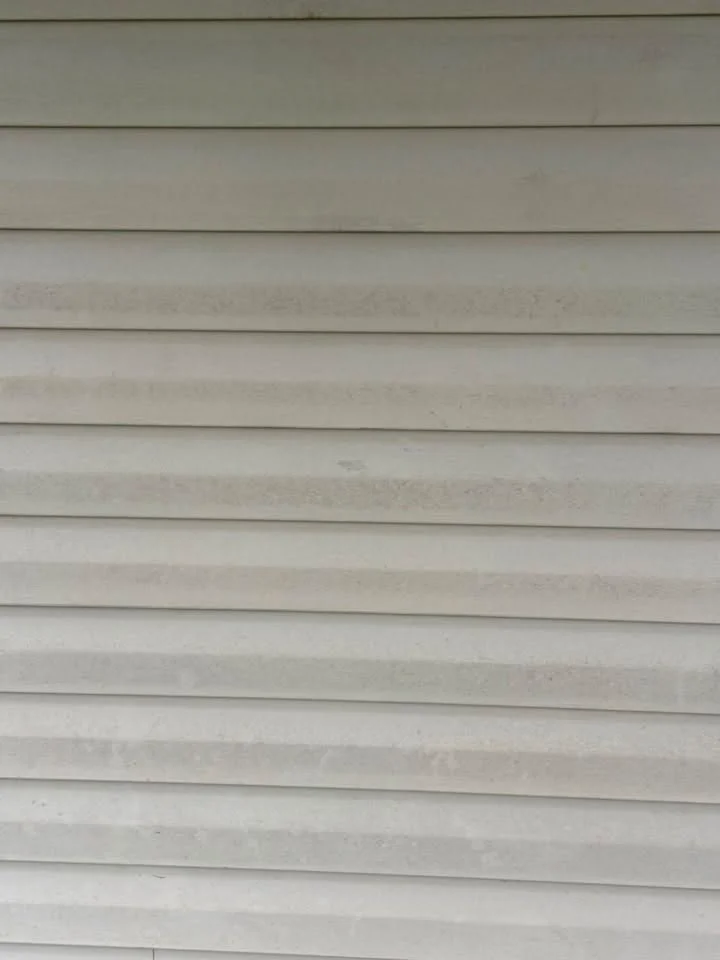 After: close view of light gray vinyl siding panels with even color and only faint banding